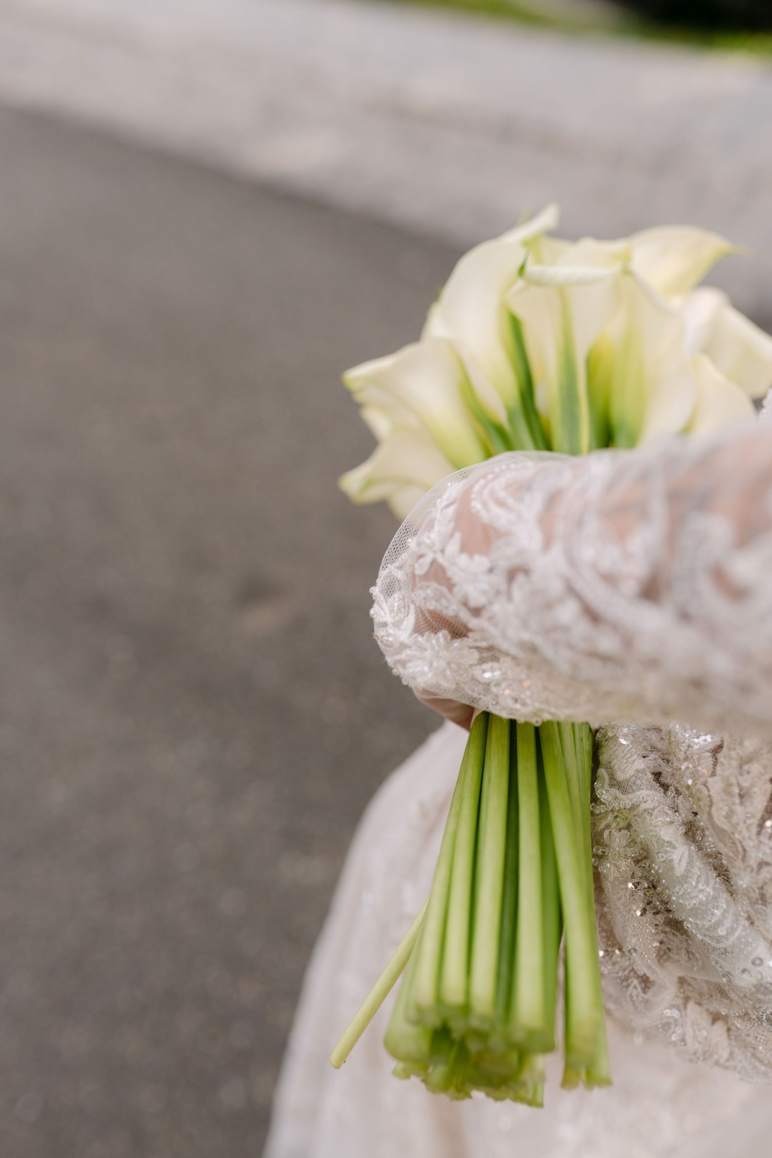 Close-up of an elegant white bridal bouquet wrapped in delicate lace.