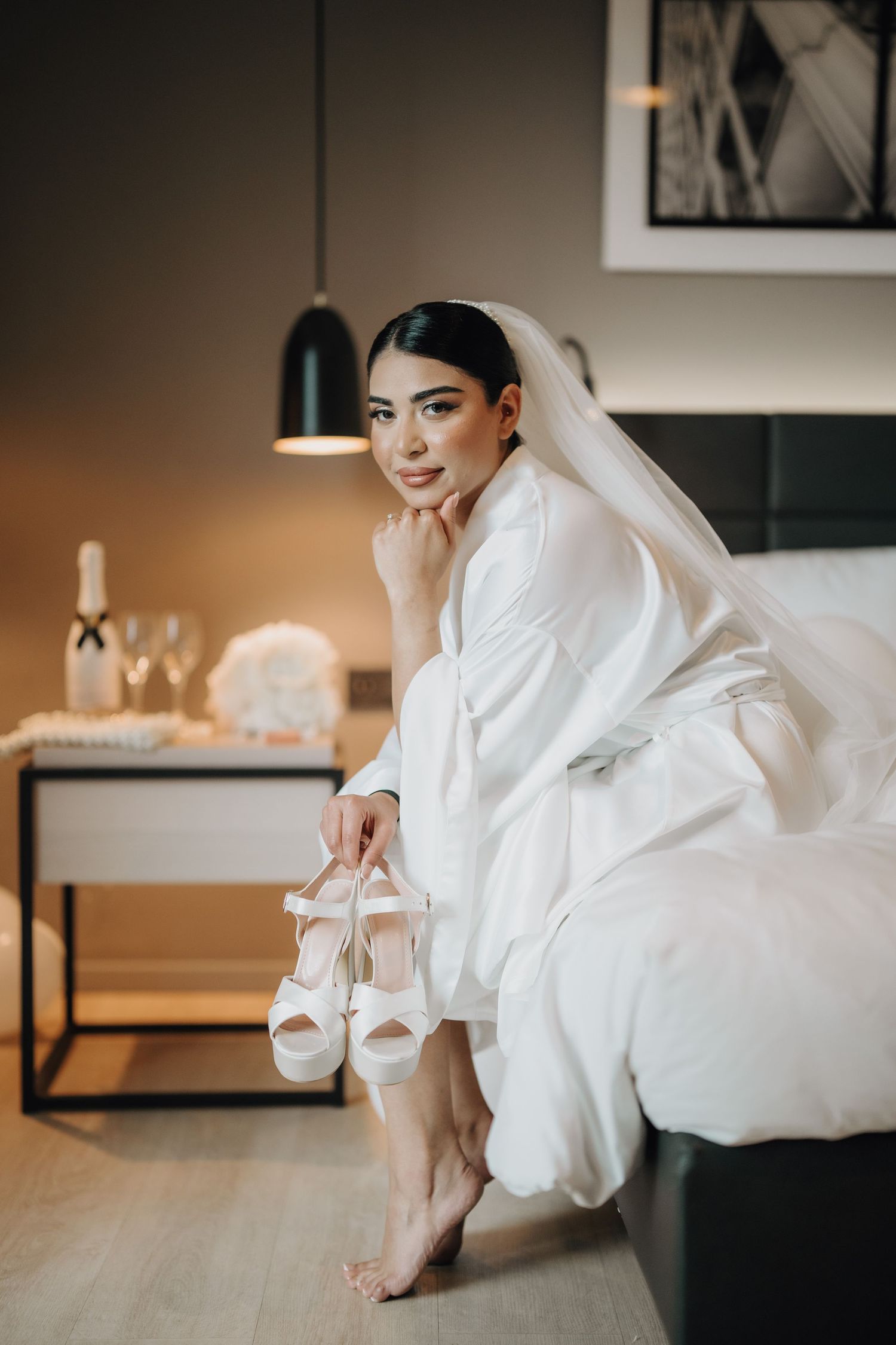 Close-up shots of bride's white wedding shoes against modern interior decor.