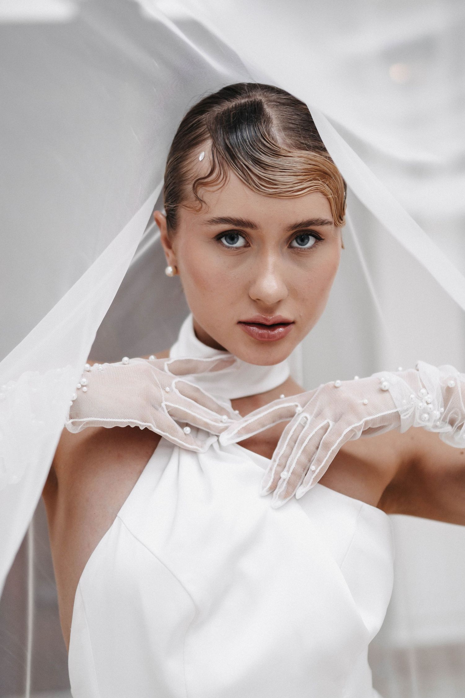 A bridal fashion series showing elegant white gloves and dramatic poses against a light background.