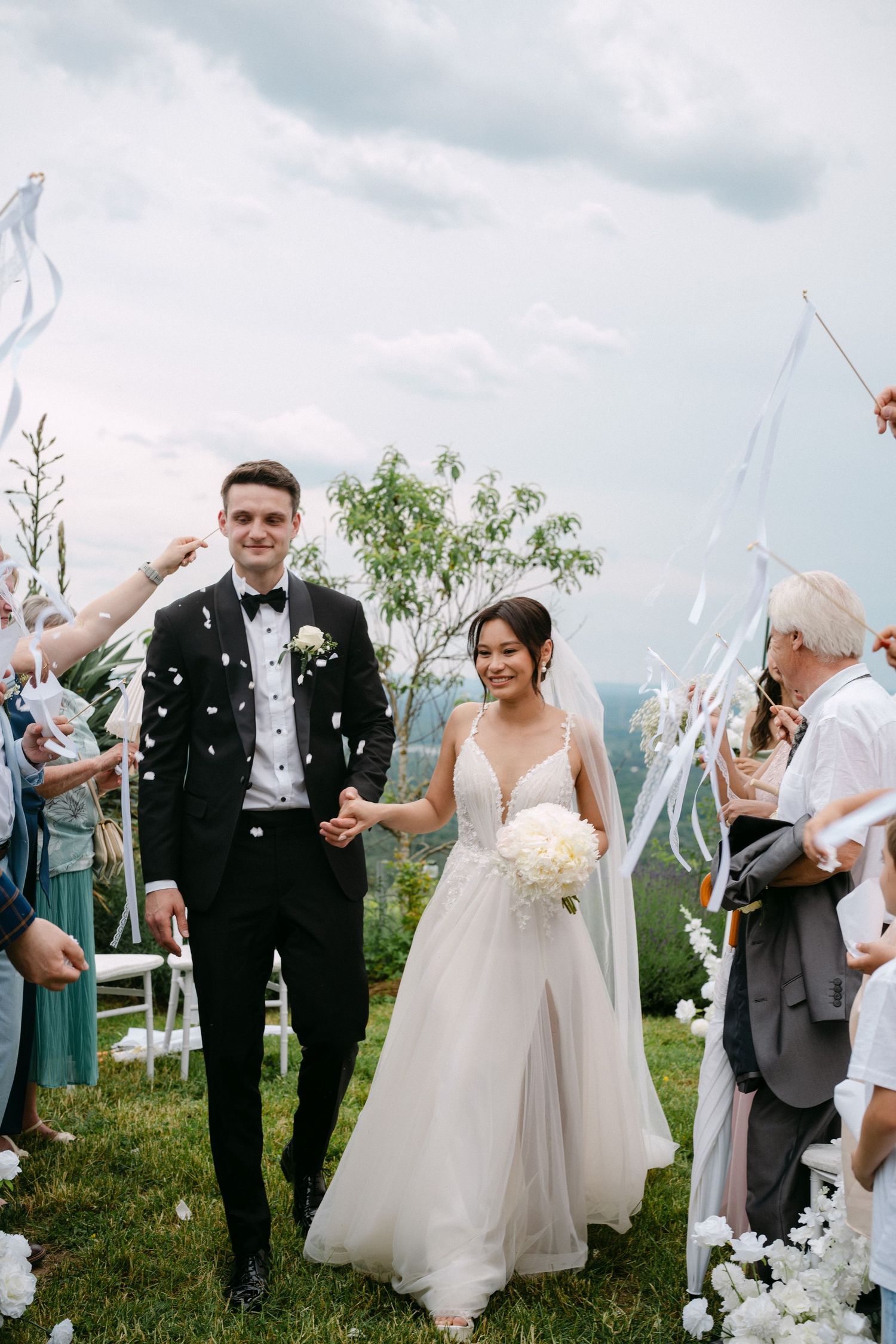 Fröhliche Hochzeitsfeier im Freien mit Gästen, die Konfetti werfen – festgehalten von Melér Wedding, modernen Hochzeitsfotografen aus Deutsc