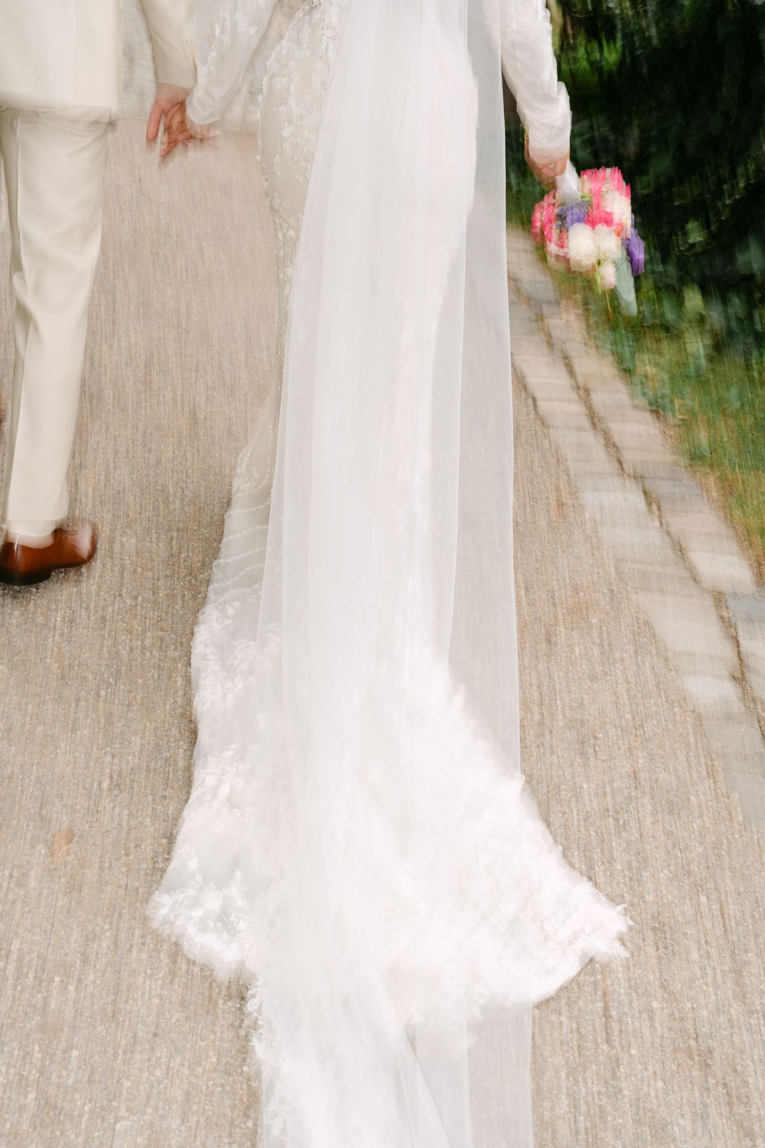 Elegant wedding attire captured in romantic outdoor garden setting.