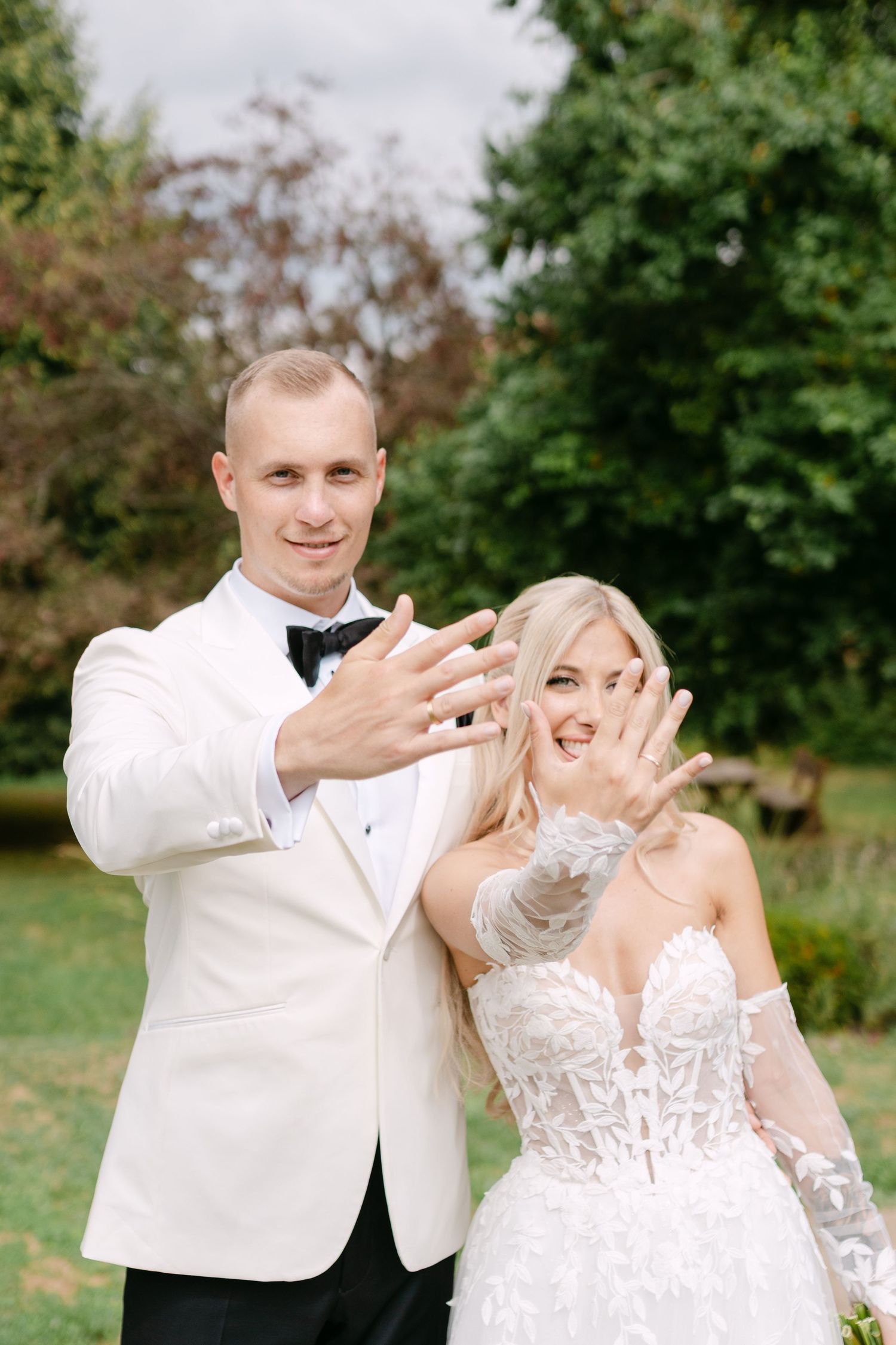 Playful wedding couple shares animated moments in an outdoor garden setting.