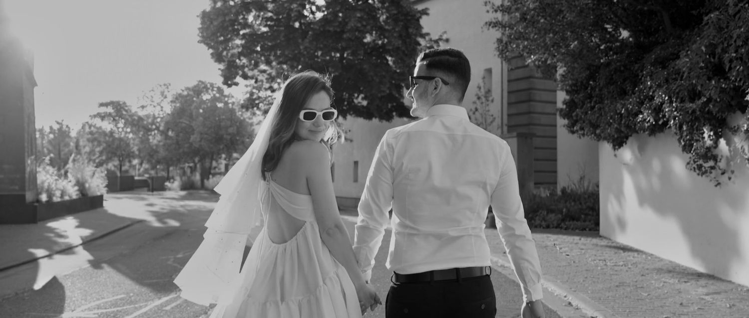 A black and white photo collage showing five romantic wedding moments in an outdoor setting.