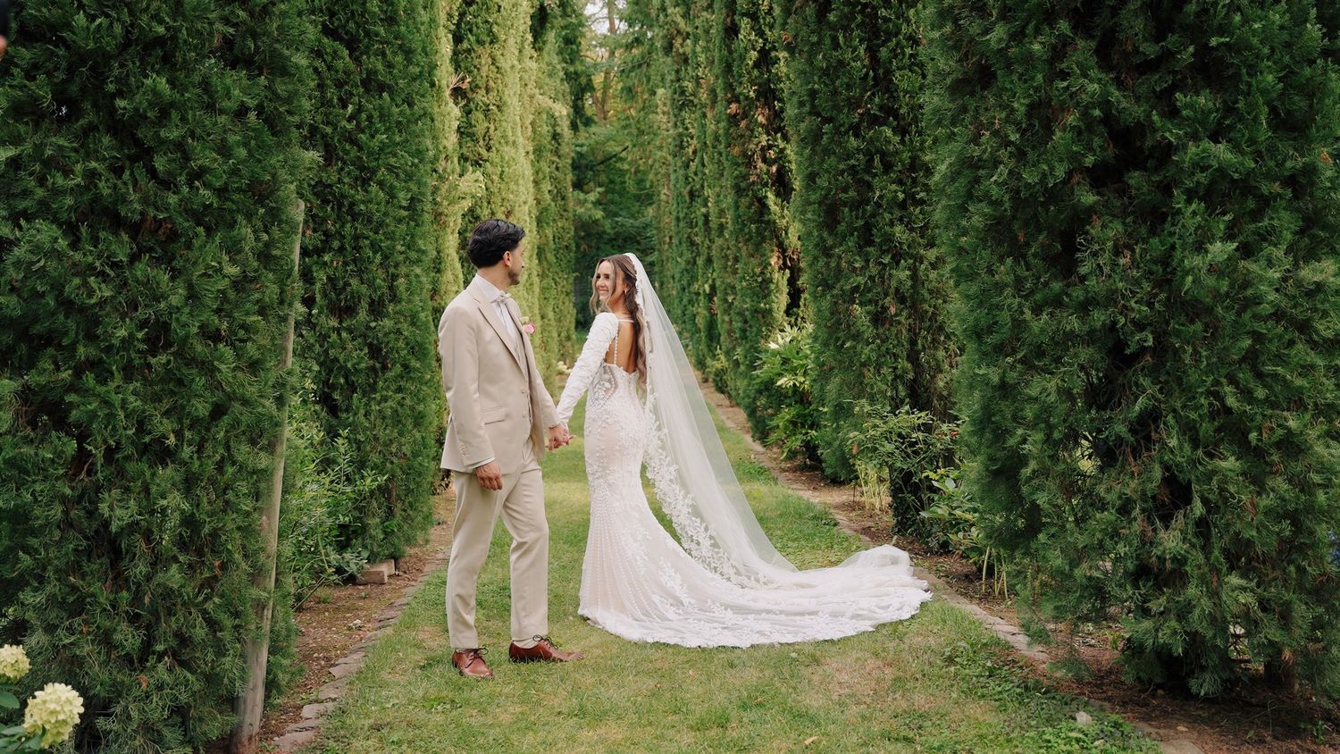 Garden wedding ceremony setup with cypress trees creating a natural aisle.