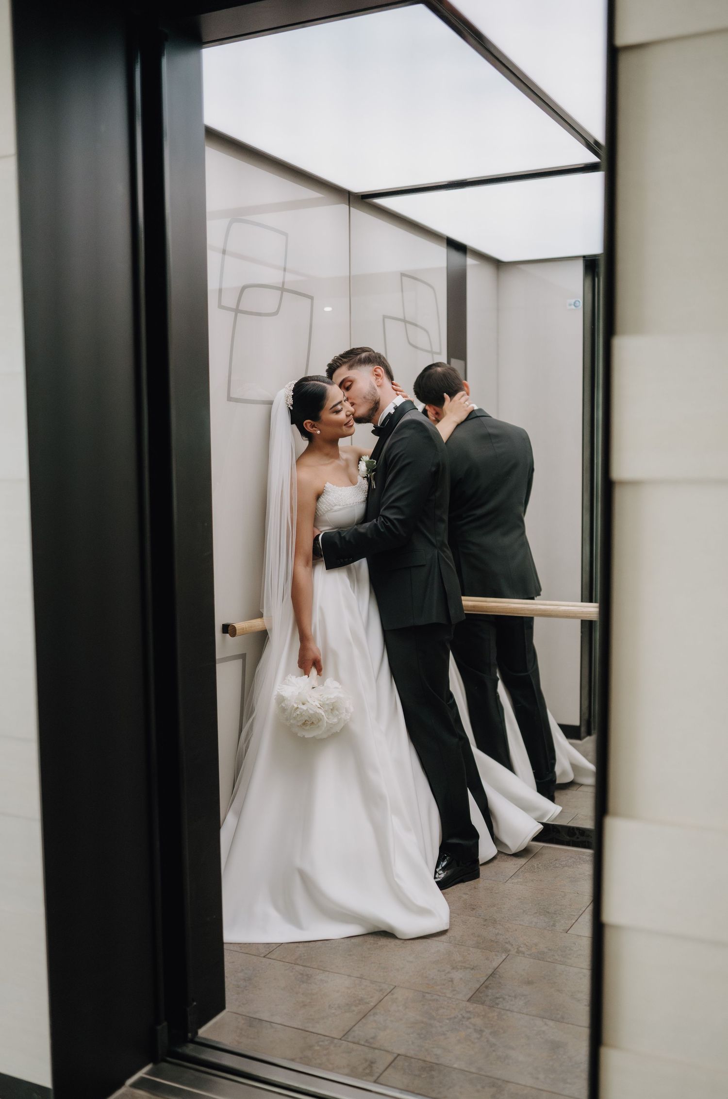 Artistic wedding photos showing couple in mirrors and reflective surfaces in a modern hallway.