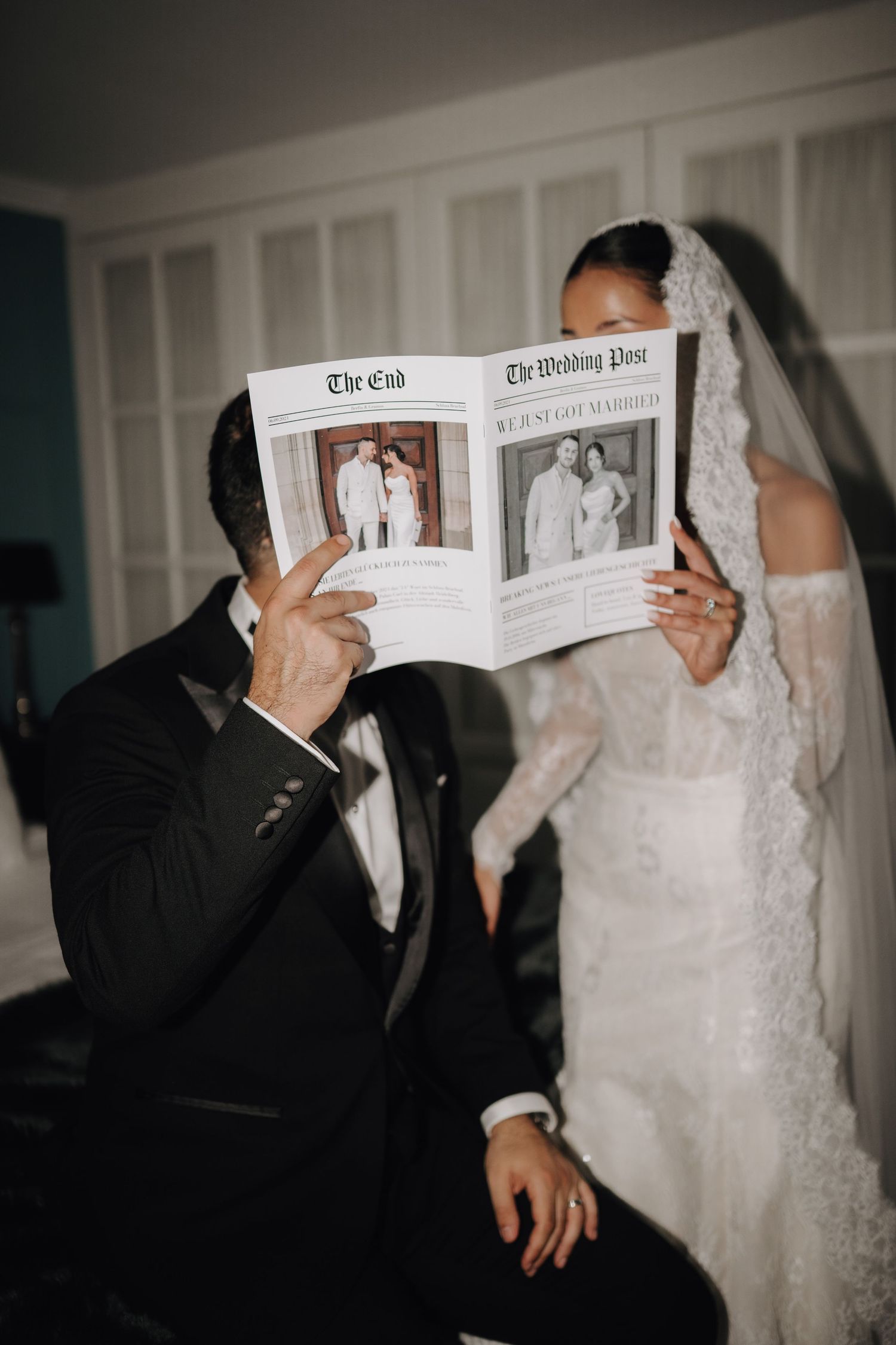 Wedding couple playfully hiding behind newspapers during a photo session.