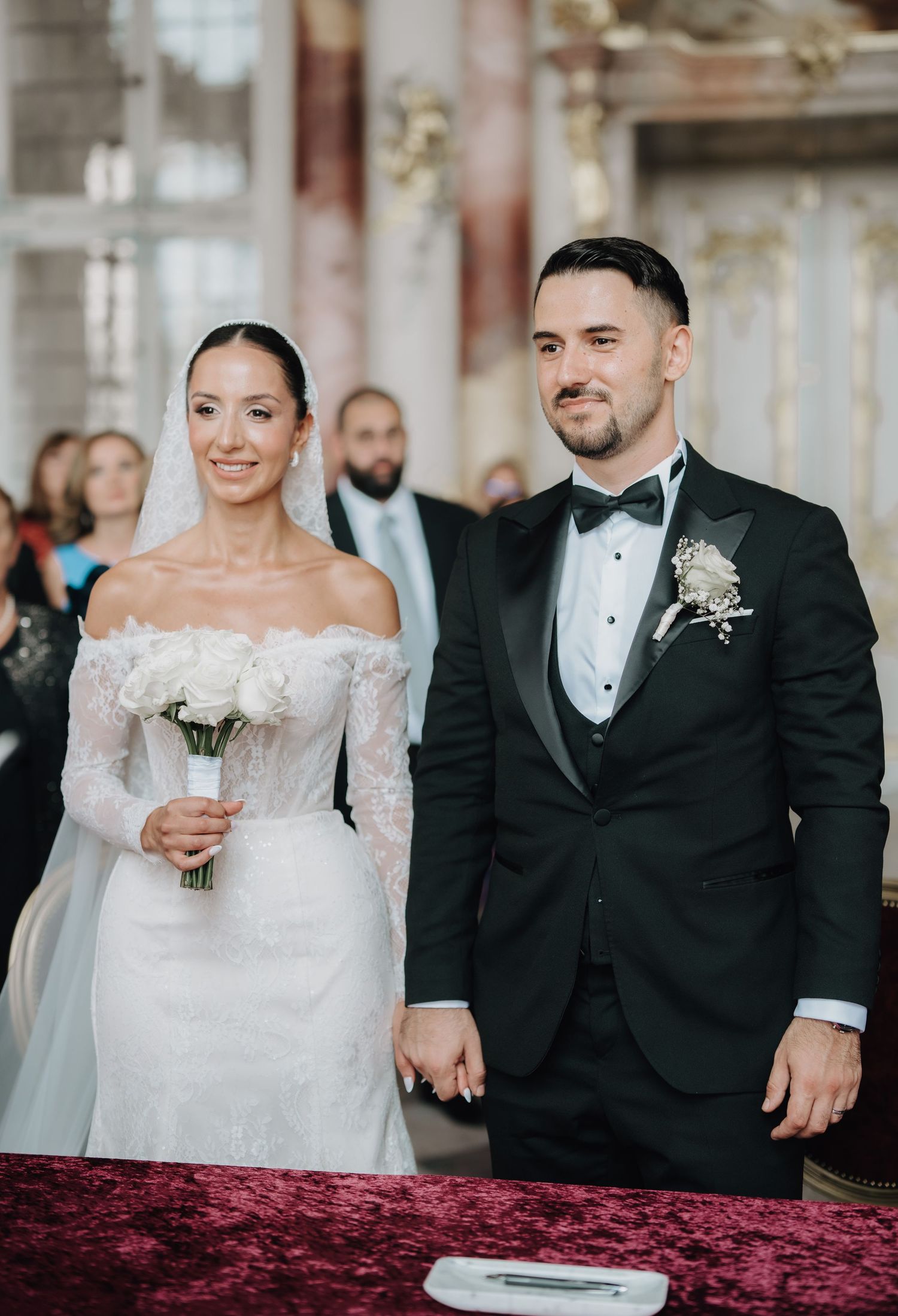 Wedding ceremony photos showing couple signing marriage documents on red velvet table.