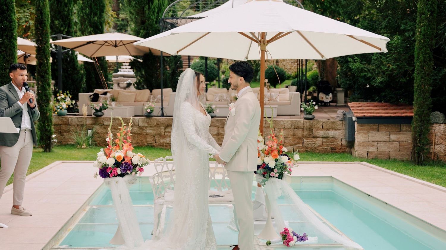 Panoramic view of an elegant swimming pool with white umbrellas at a luxury venue.