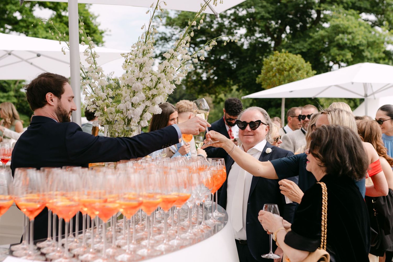 Outdoor reception setup with champagne glasses and elegant table settings.