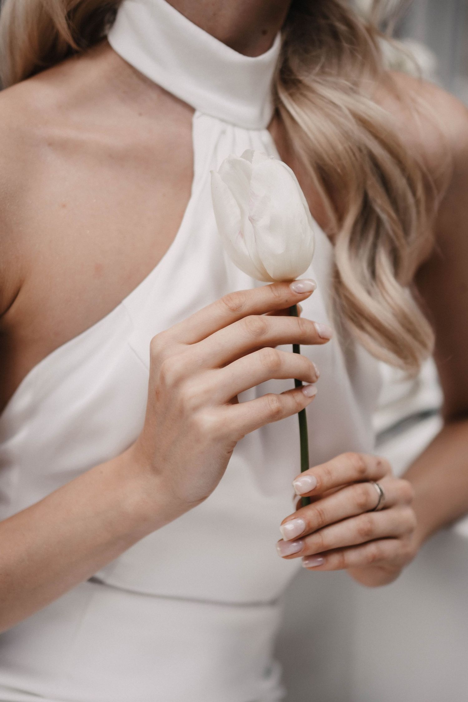 Close-up detail of white floral elements and elegant wedding dress neckline.