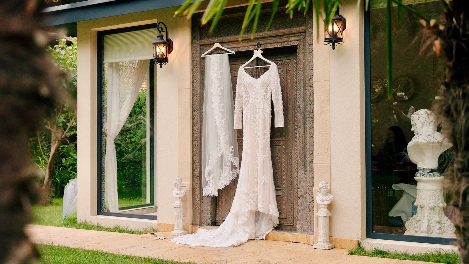 Wedding attire and decorative elements arranged along a Mediterranean-style building exterior.
