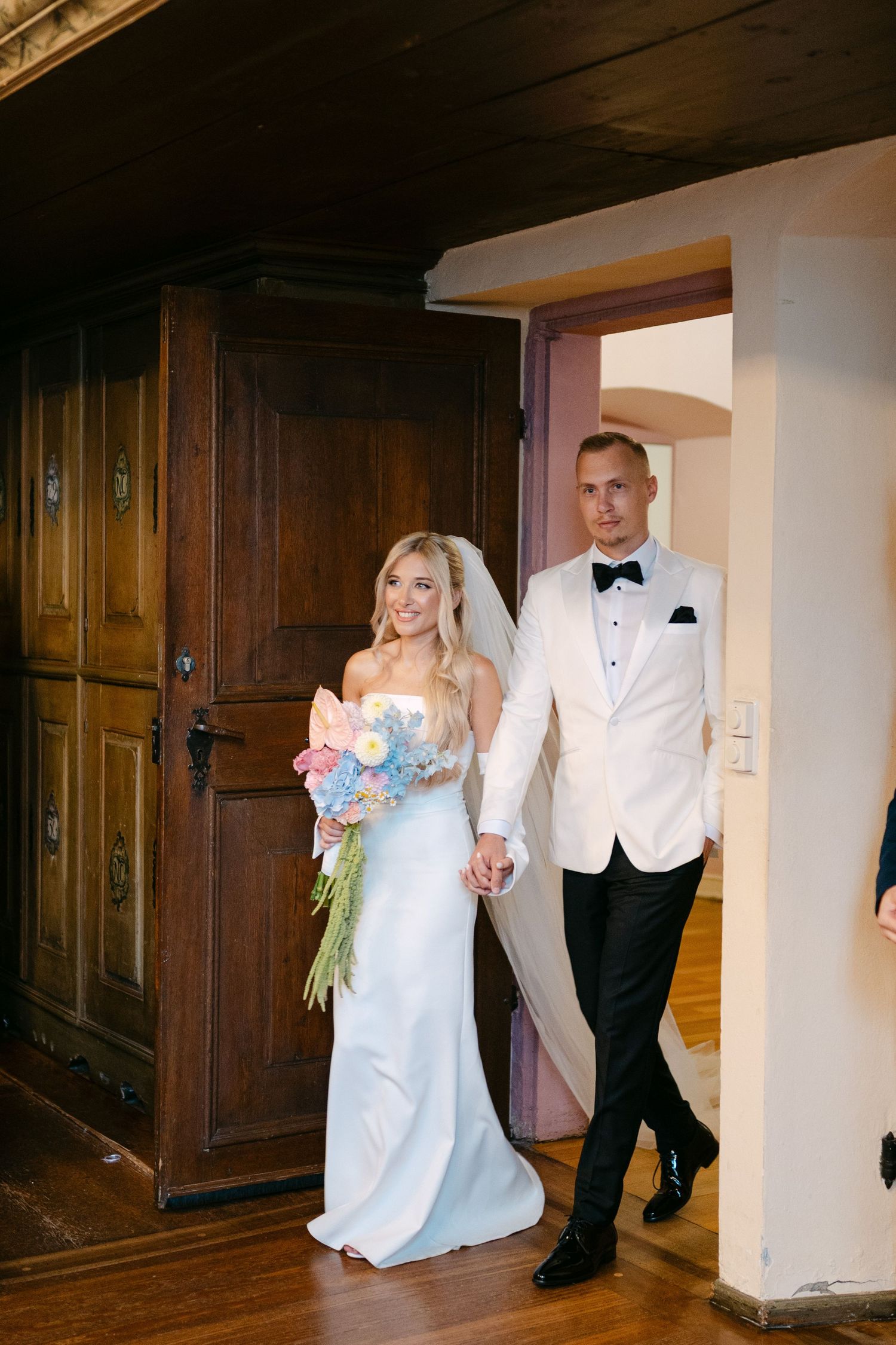 Wedding couple dancing in an elegant wood-paneled interior room.