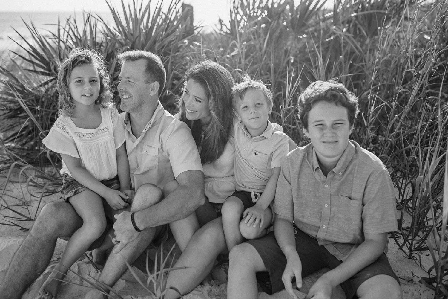 Family on the beach in black and white.