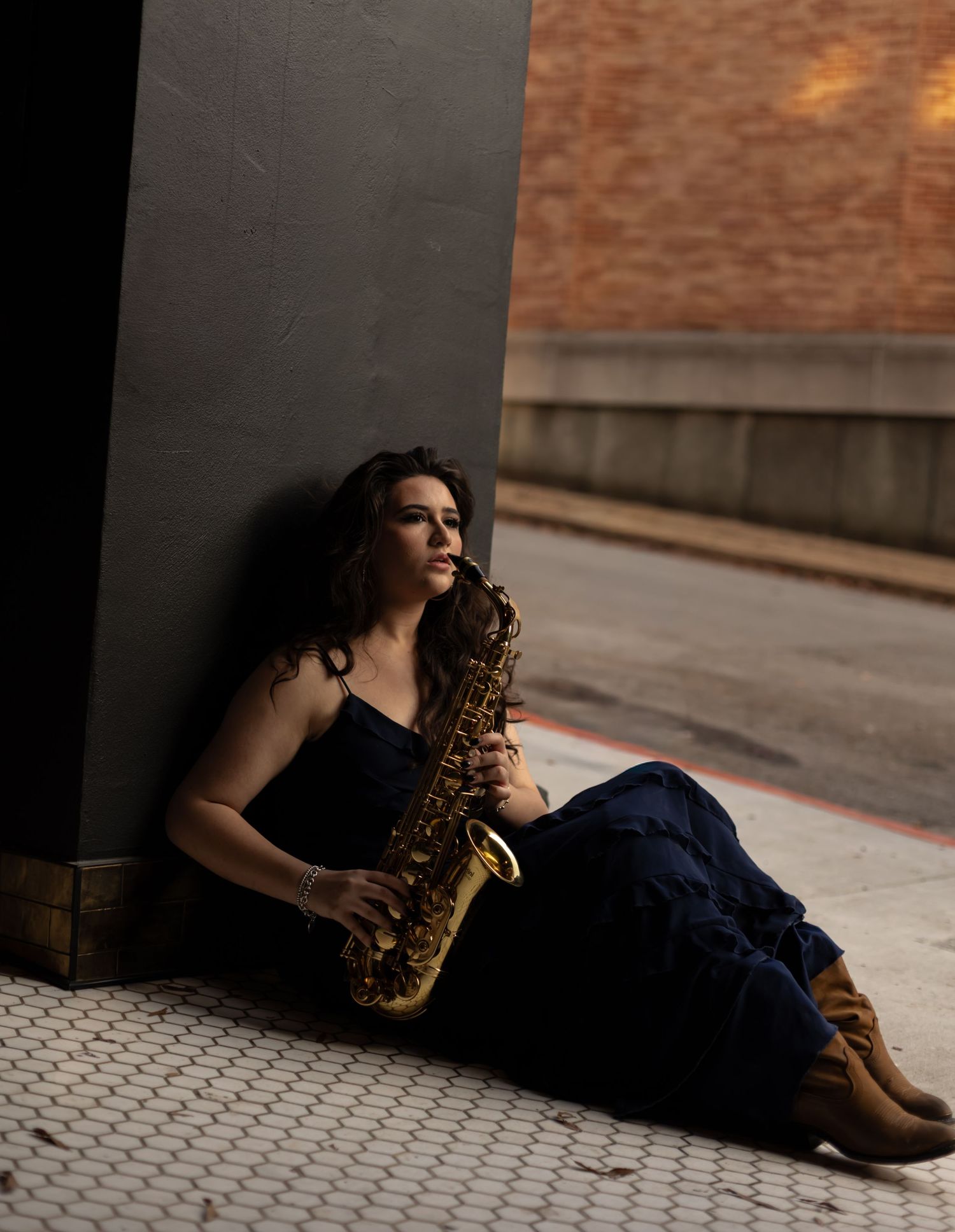 Senior playing her saxophone downtown chattanooga at sunset.