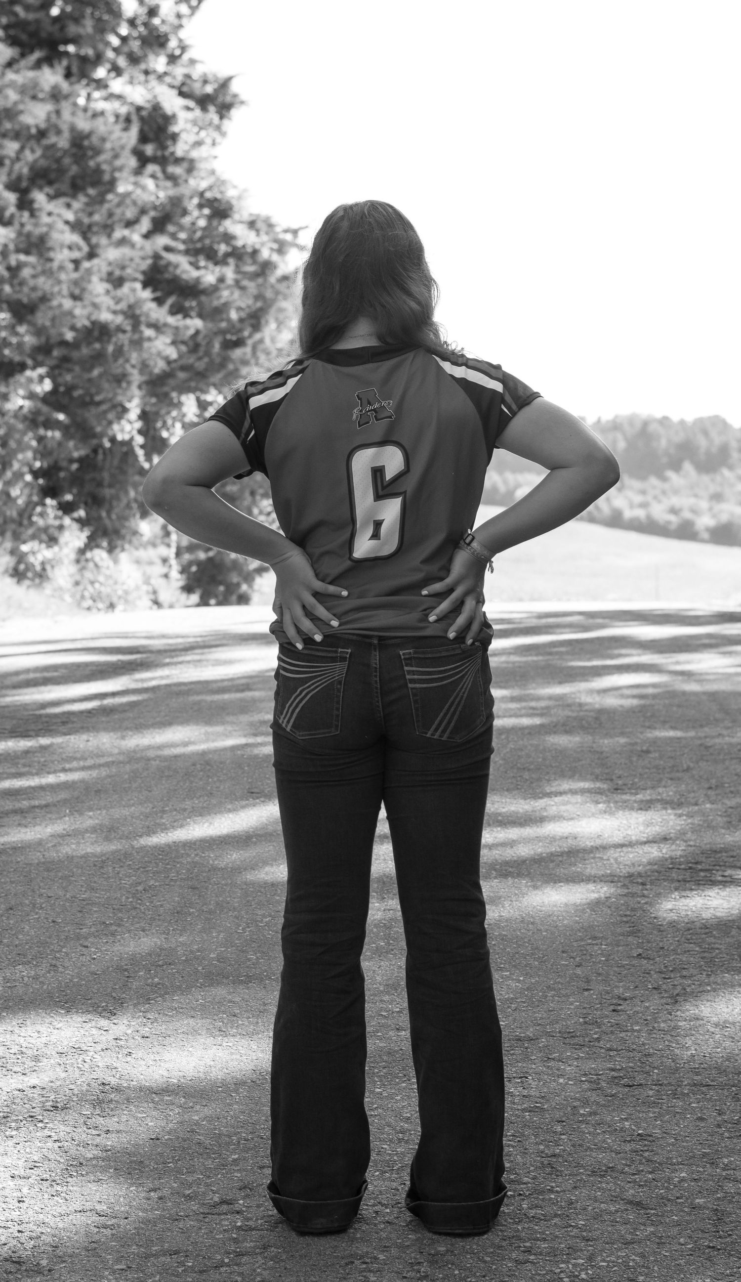 Black and white series showing casual poses against a sunlit outdoor background.
