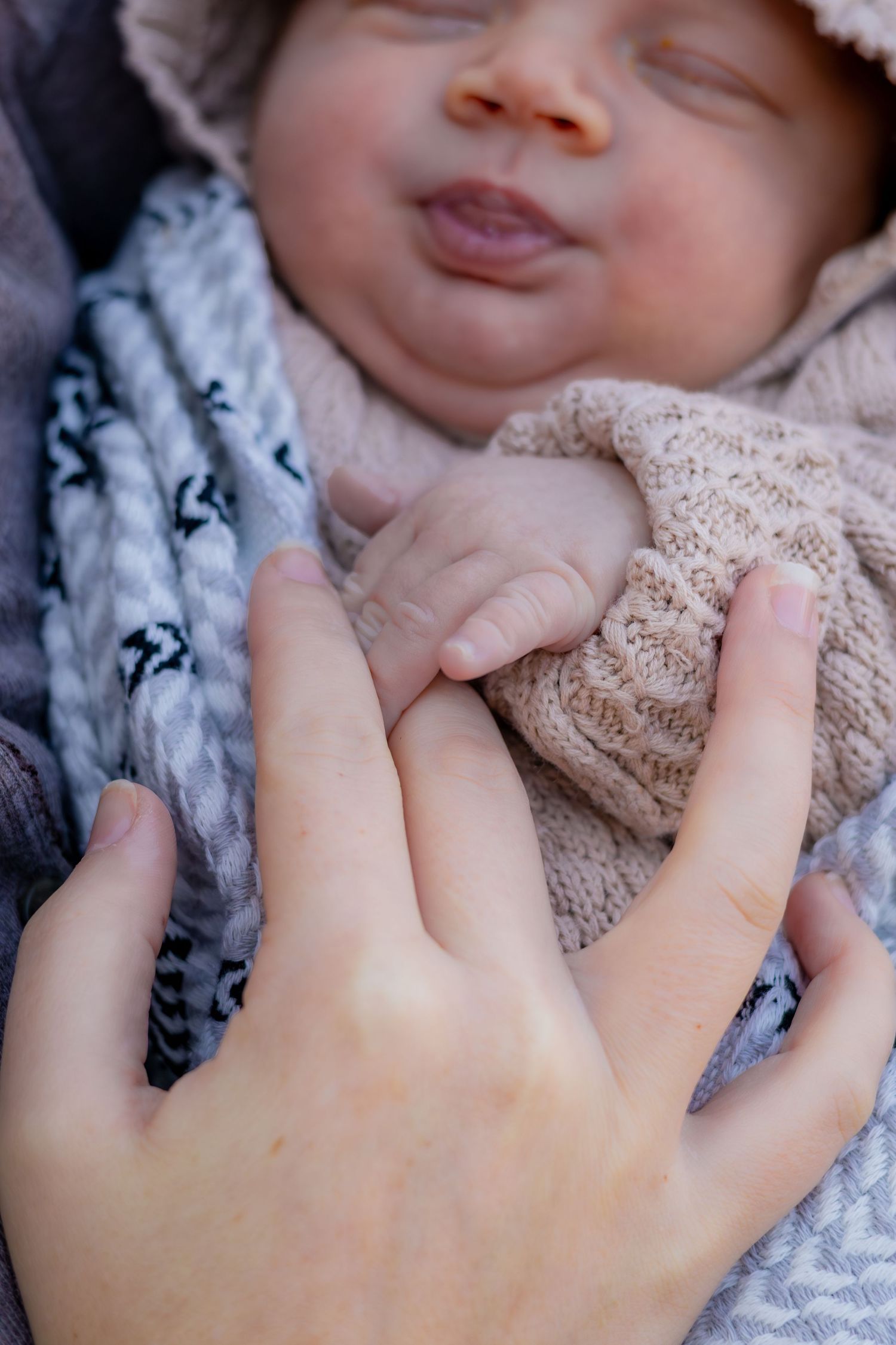 Close-up series of a baby's hand grasping and holding onto a delicate lace fabric.