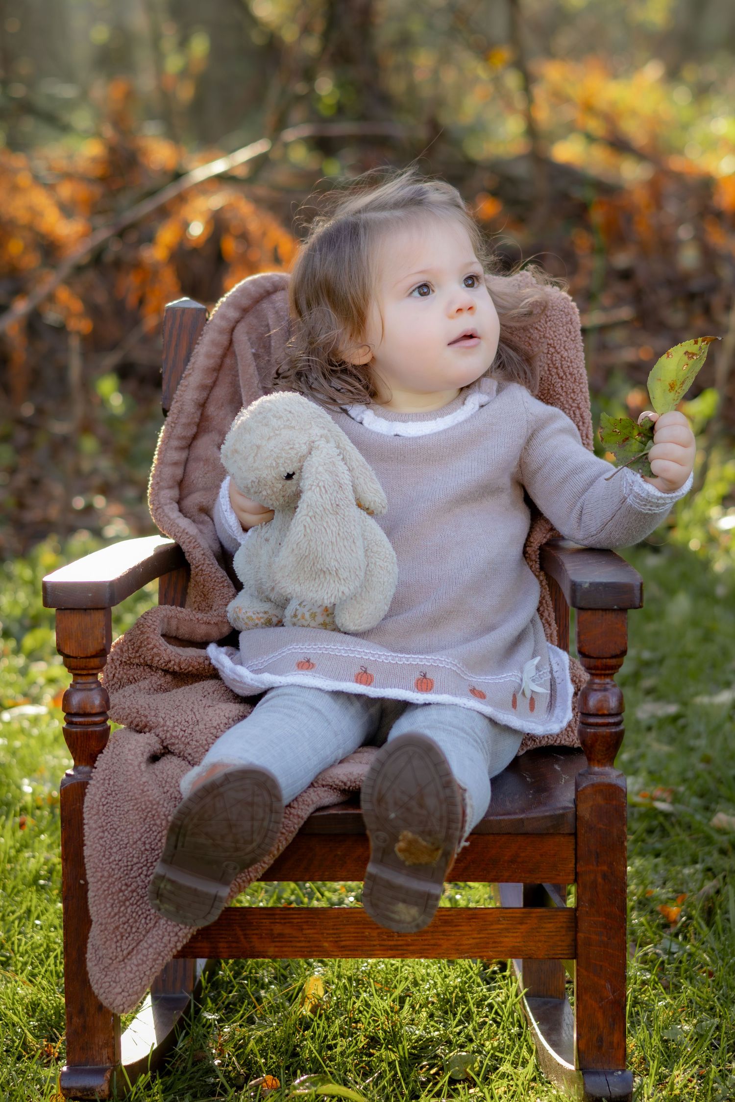Wooden bench with cozy brown blanket in autumn forest setting.