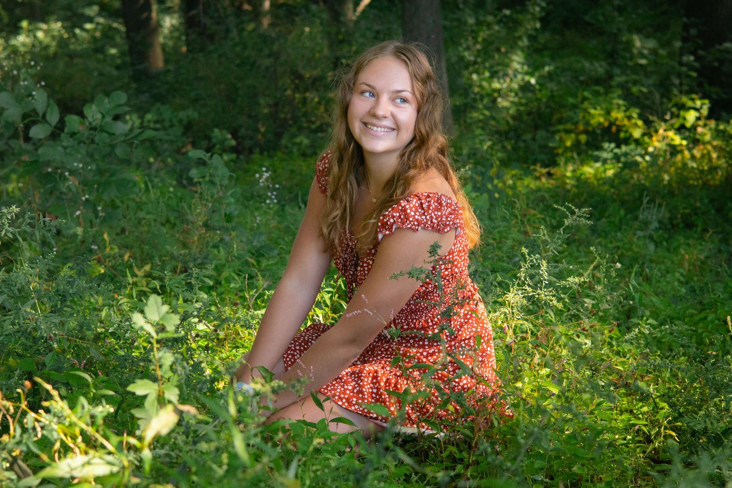 Summer portrait session in a lush green garden setting.