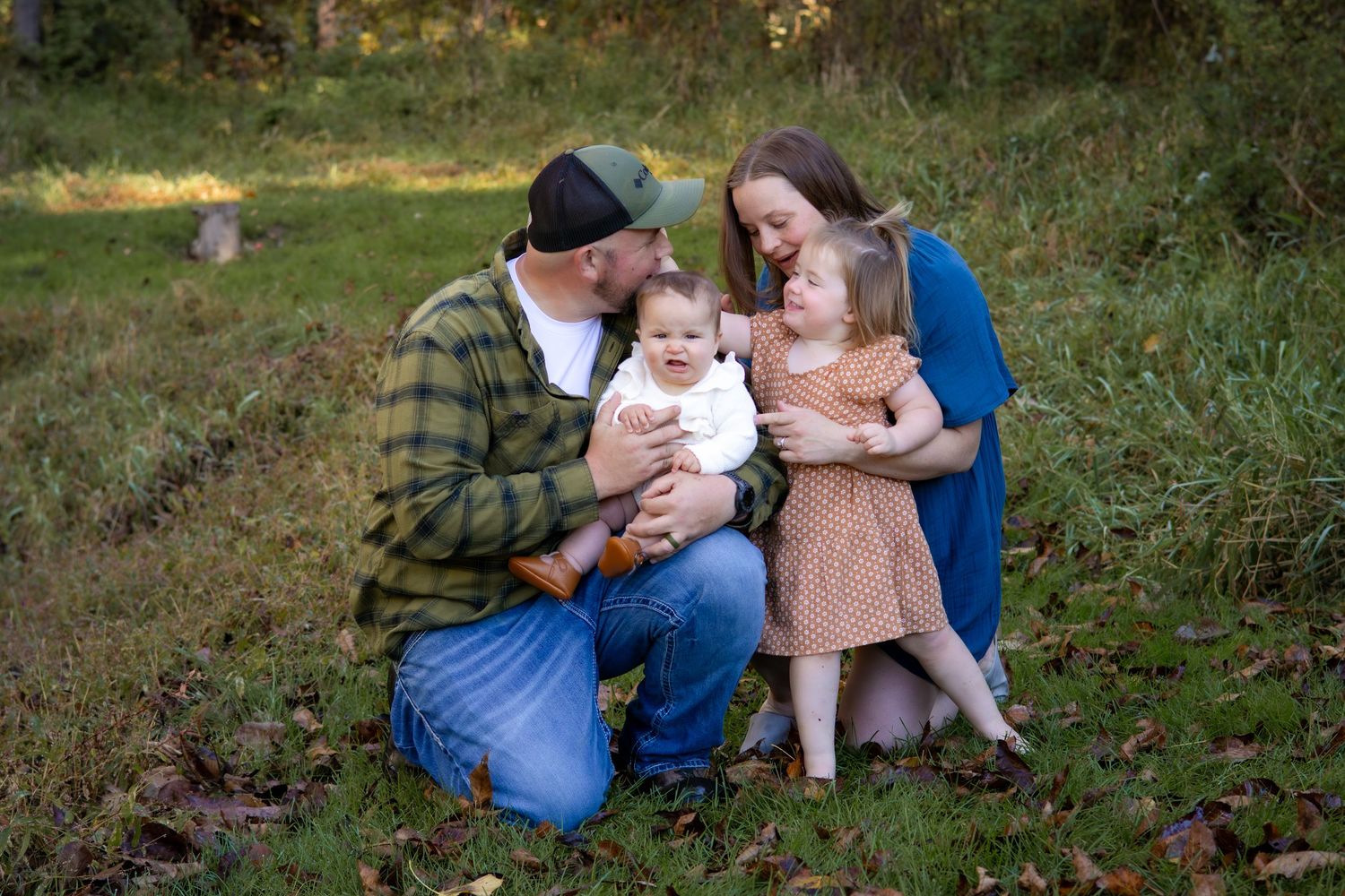 Casual outdoor family portraits with natural interactions in a field setting.