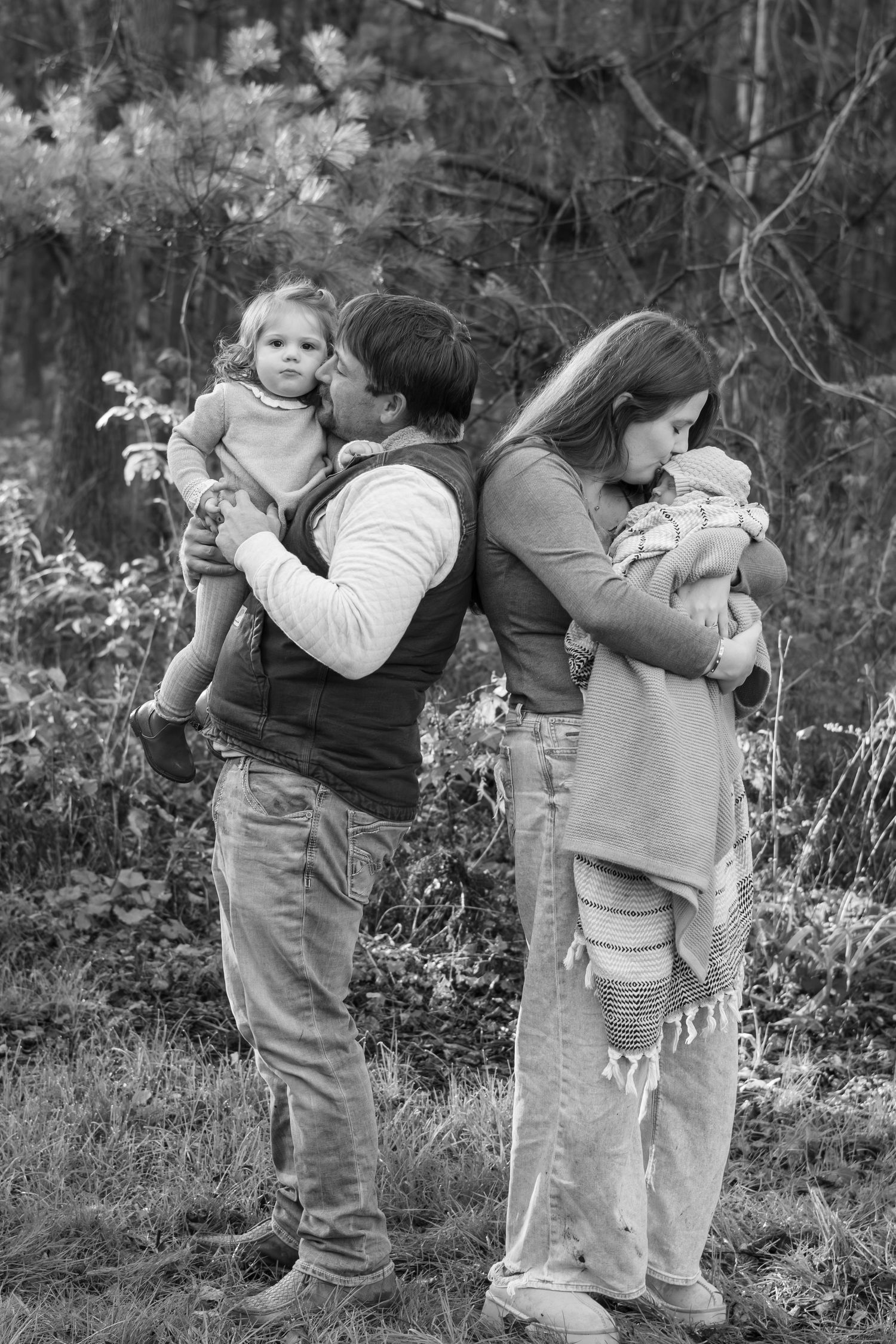 A black and white family photo series showing tender embraces and connections.