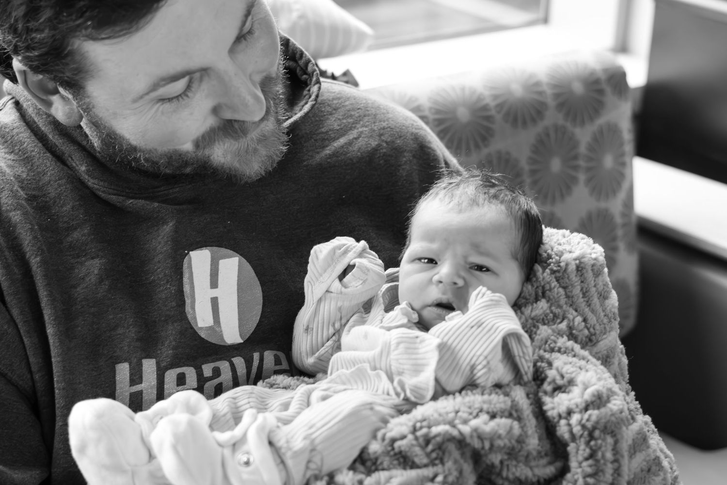 Tender moment shared between parent and infant wrapped in cozy blanket.