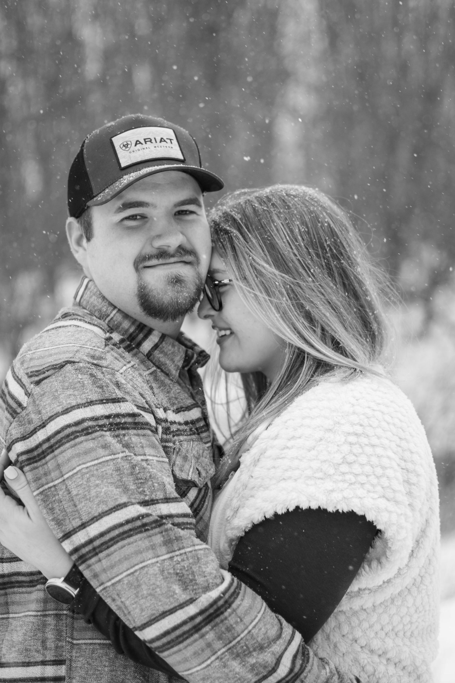 Romantic winter couple in warm clothing sharing intimate moment in snowy setting.