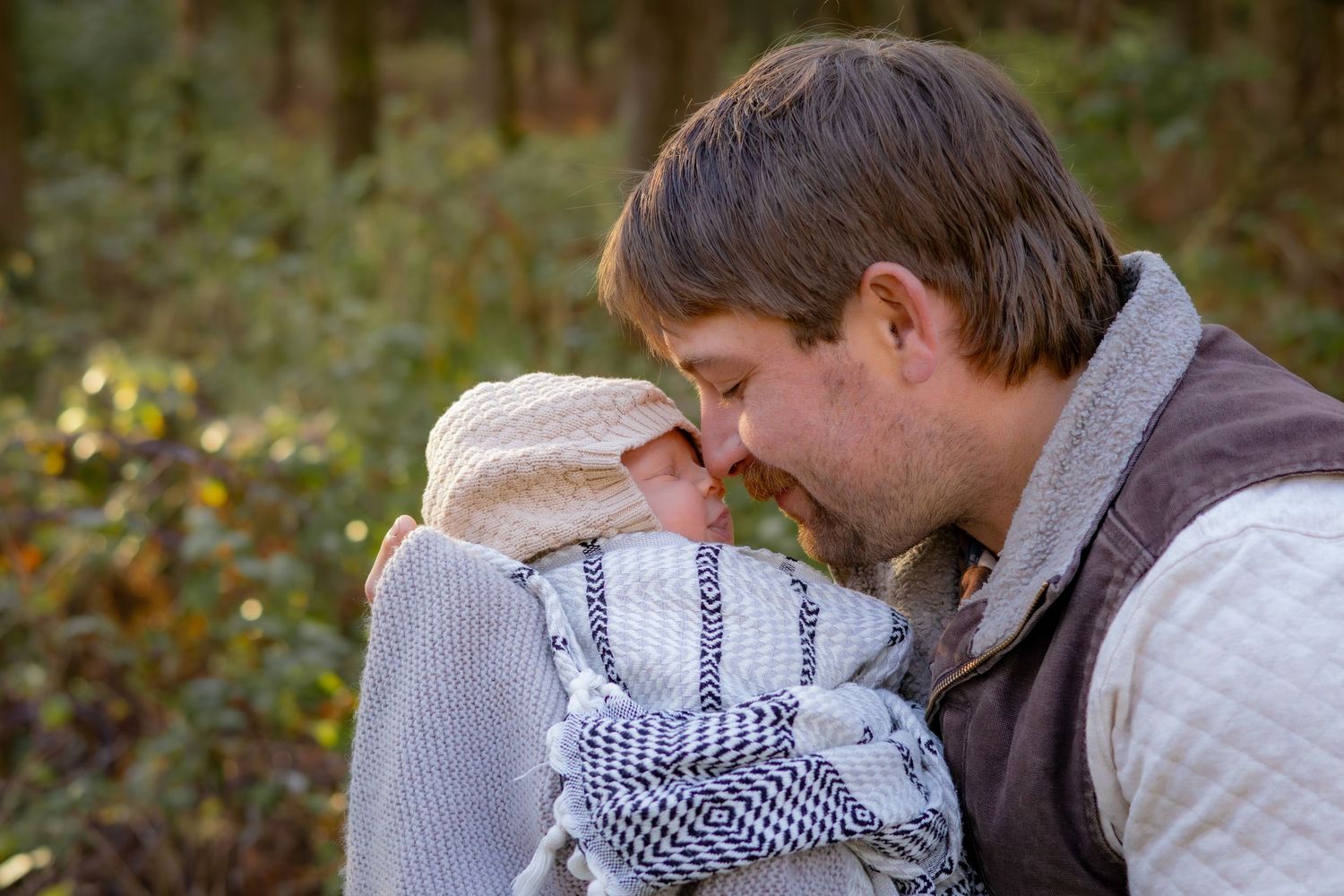 A tender moment shared between parent and child outdoors in an autumn setting.
