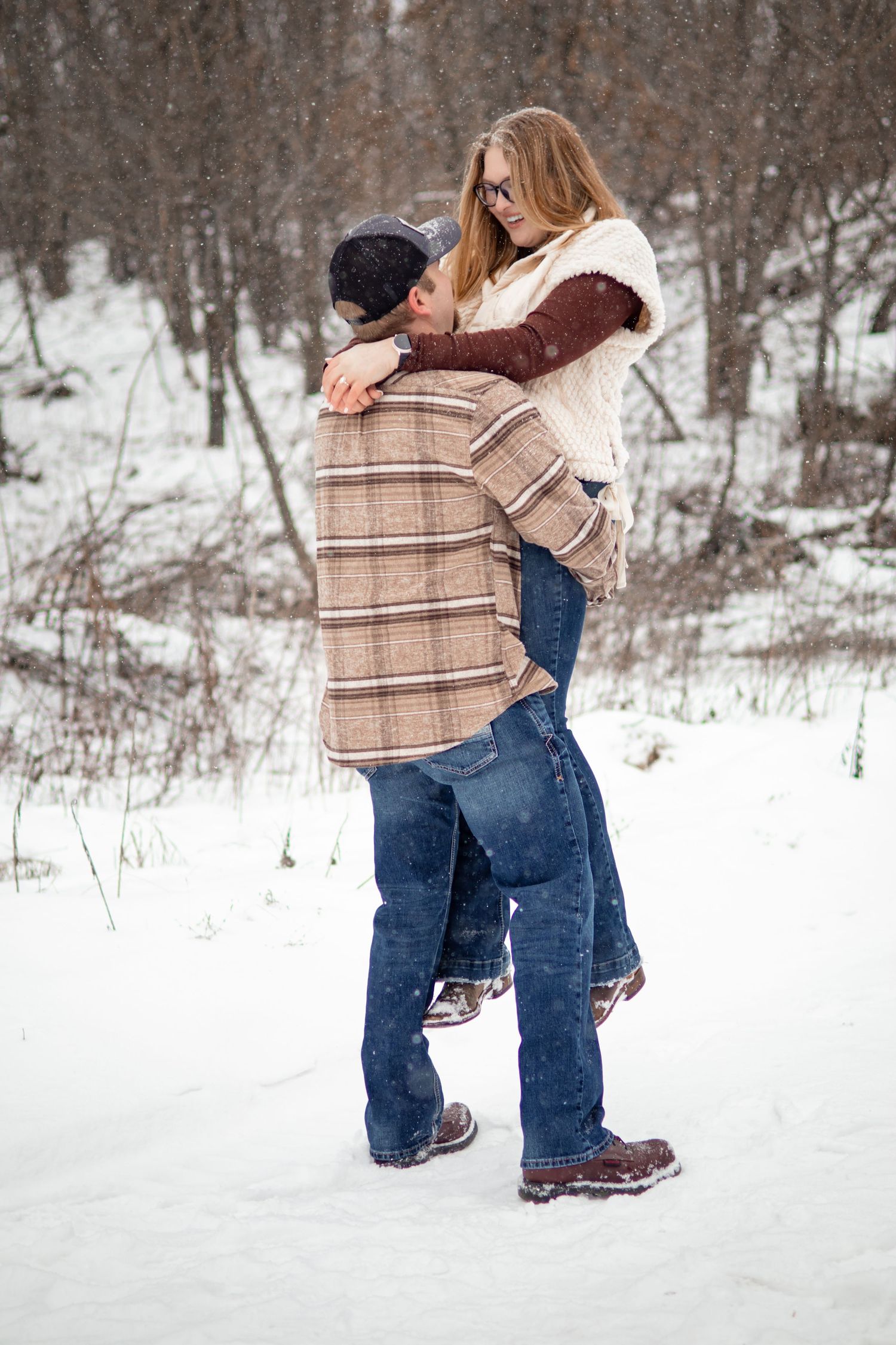 Couple sharing tender moments in a snowy winter landscape.