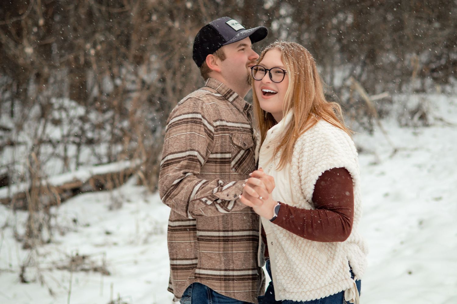 A romantic winter engagement photo session in a snowy forest.