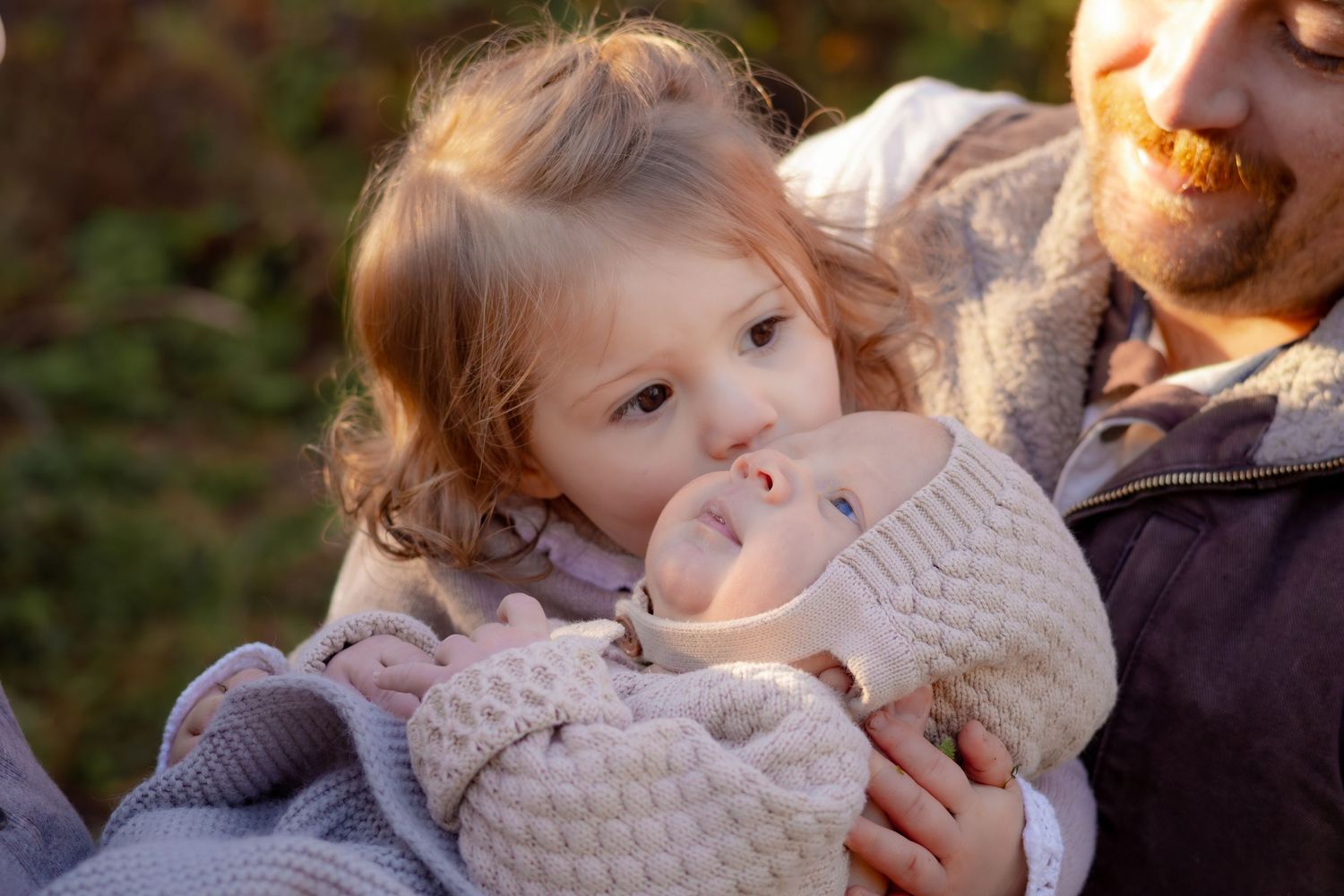 A tender family moment shared outdoors during an autumn photoshoot.