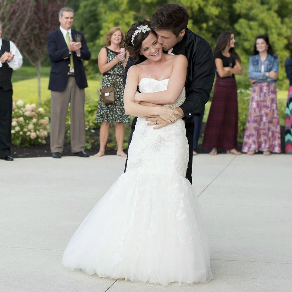 Bride and groom sharing romantic first dance in wedding celebration outdoors.