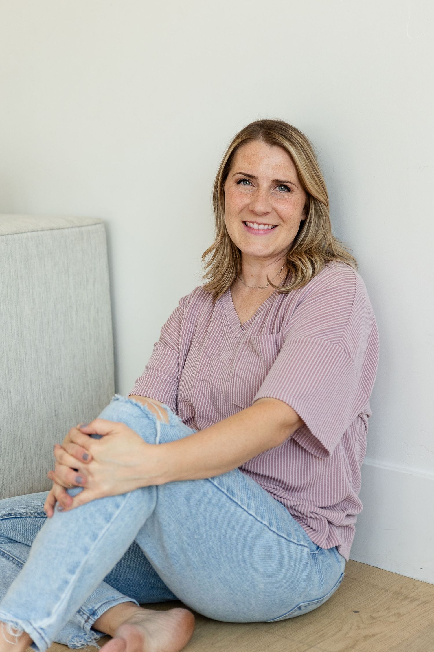 woman smiling at camera sitting on floor southern utah photographer