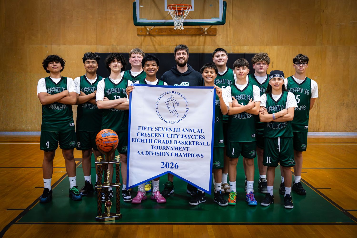 Crescent Elk Cougars 8th grade basketball team poses with 2026 AA Division Champions banner.