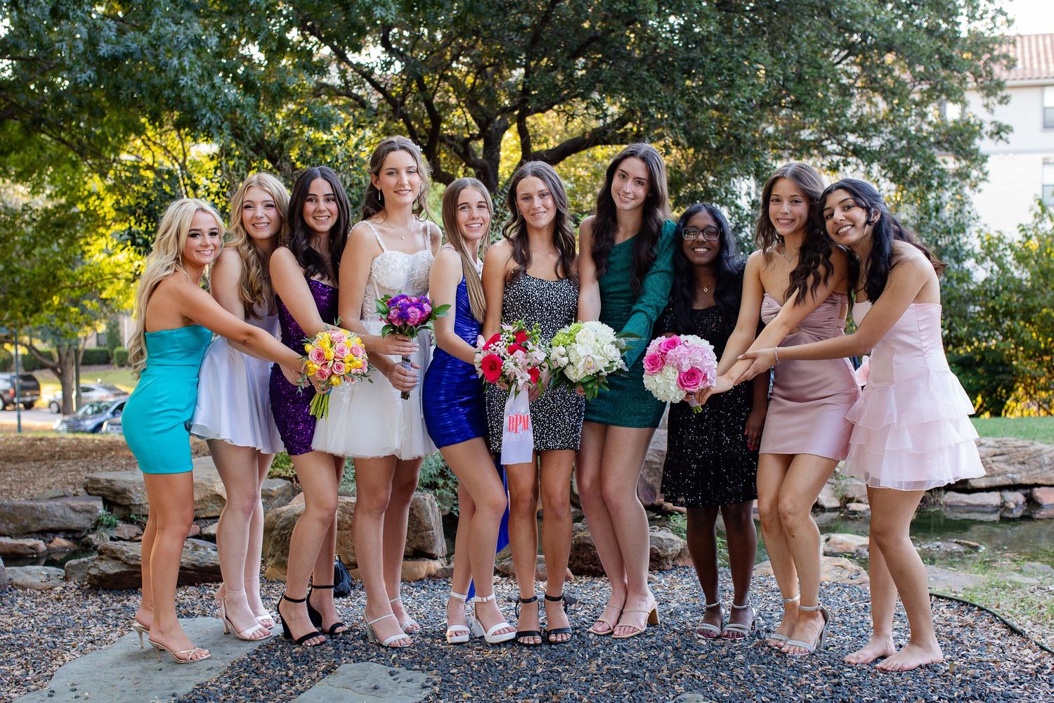 Group of coordinating shoes and feet arranged in a playful line formation outdoors during a celebratory event.
