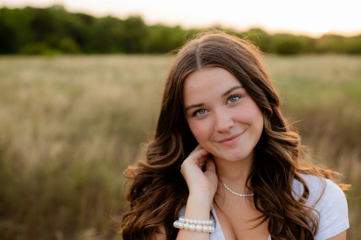 A portrait in a golden evening field with warm sunlight and soft bokeh background.
