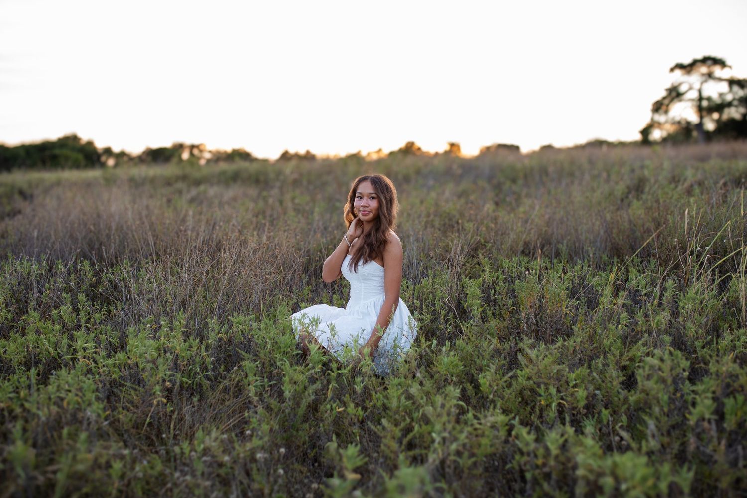 A sequence of romantic outdoor engagement photos shows a couple posing together in a natural field setting at sunset.