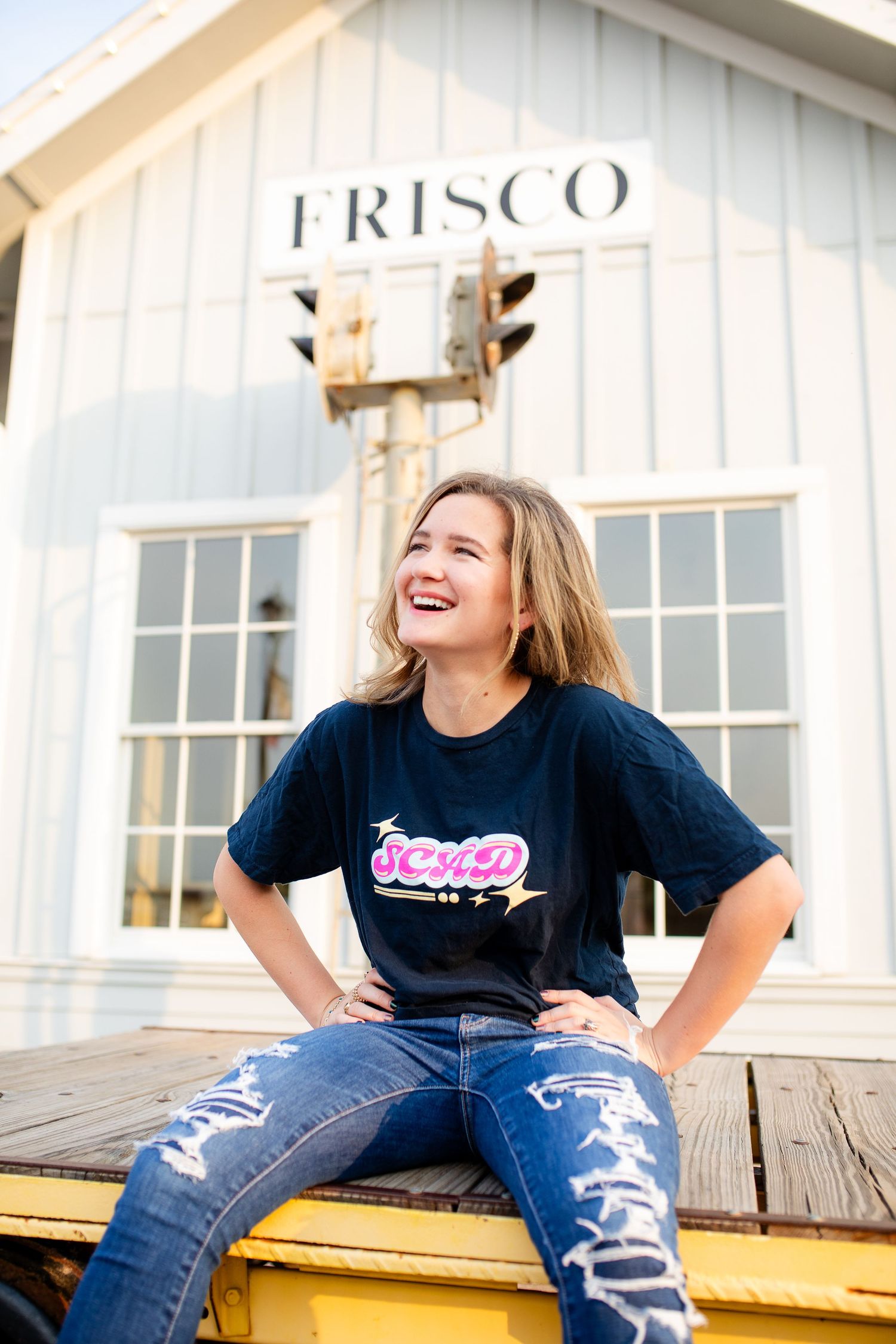 A set of three casual portraits taken on a wooden deck with a white building marked 'FRISCO' in the background.