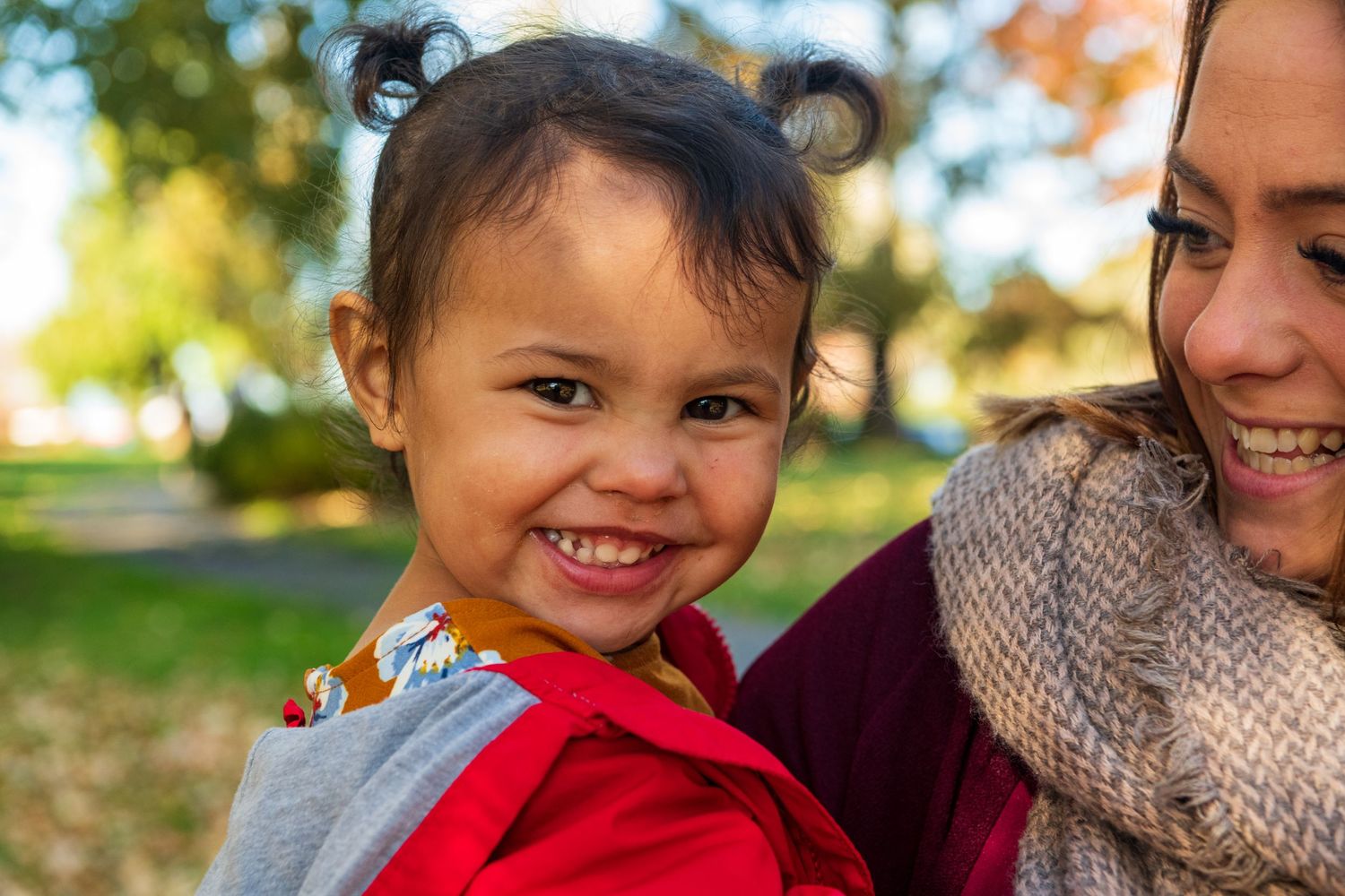 A series of joyful candid moments captured outdoors during autumn with colorful fall foliage in the background.