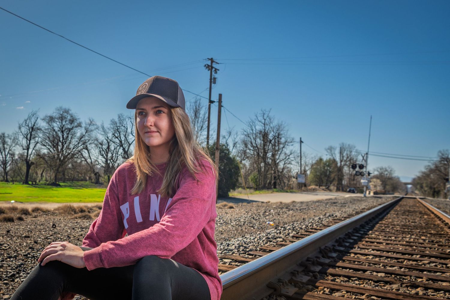 A collection of railroad track photos featuring a person in pink posing near train tracks on a sunny day.