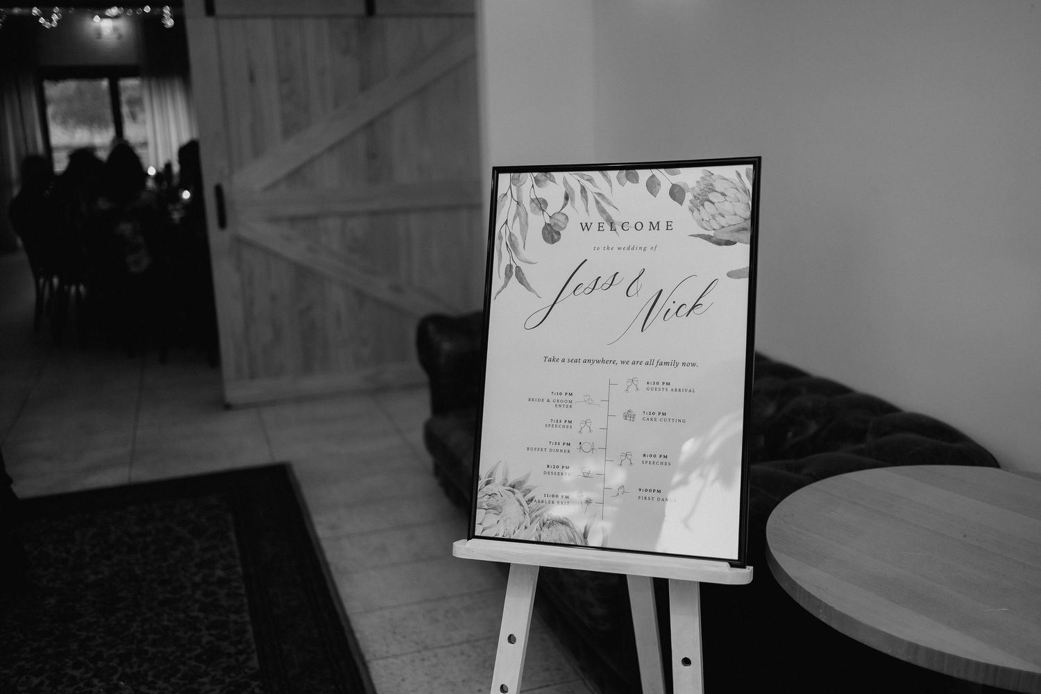 Black and white welcome sign for Jesse and Nick wedding displayed on easel.
