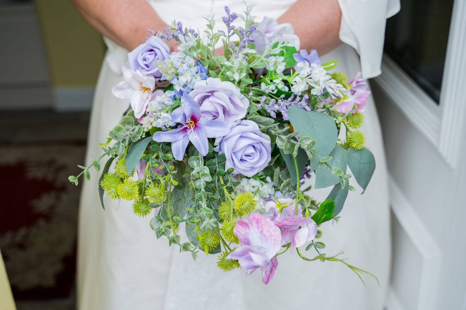A collection of delicate purple and white floral wedding bouquets arranged in a row.