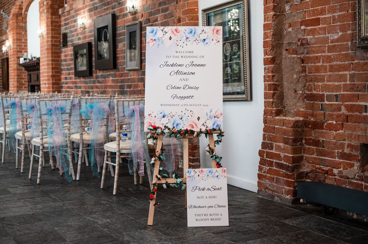 Rustic brick wall interior with hanging chairs and colorful confetti decorations in an event space.