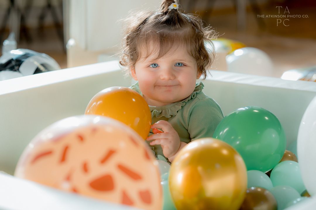 Colorful bath time scene with balloons and bubbles.
