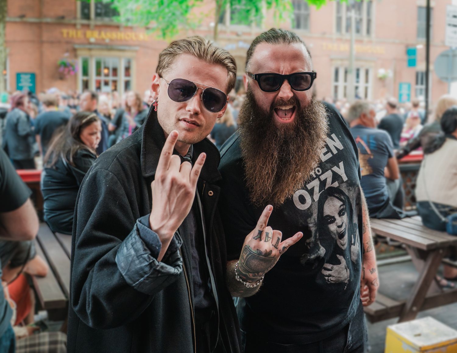 People gathered outdoors wearing dark clothing and sunglasses.