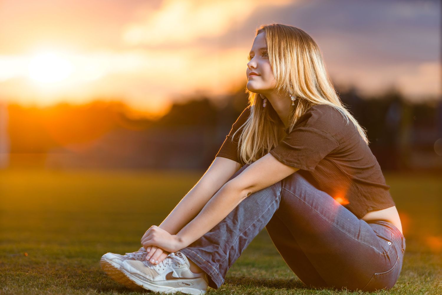 Athletic person stretches and exercises outdoors during golden sunset in a grassy field.
