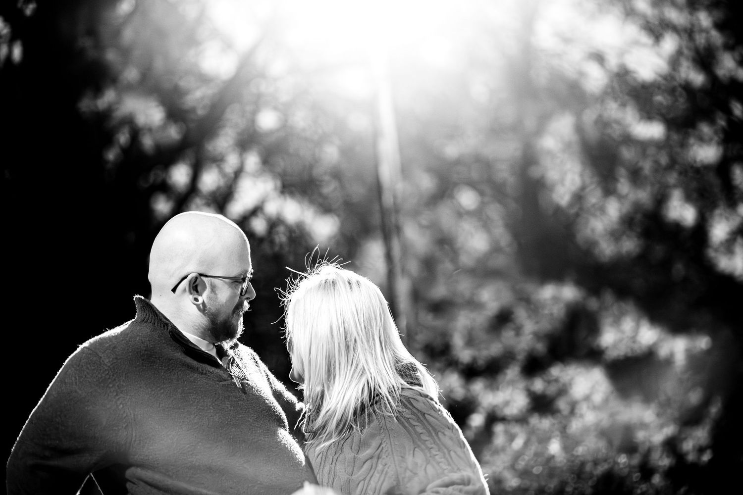 A couple shares an intimate black and white moment together in a romantic outdoor setting.