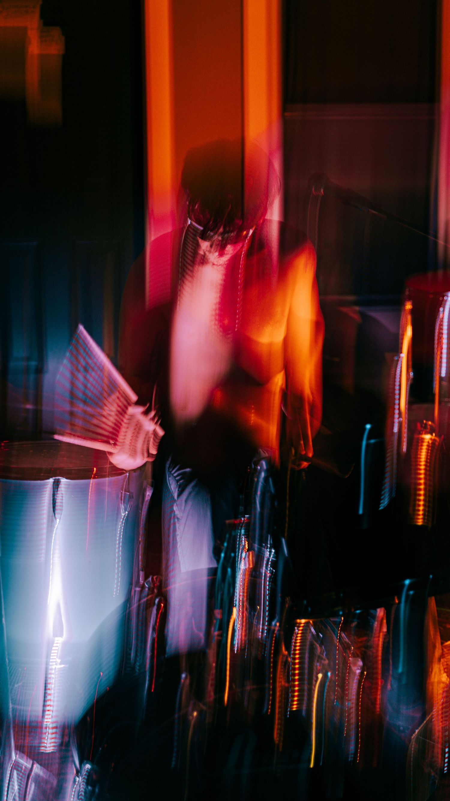 Abstract motion blur of concert lighting creating streaks of orange and blue colors.