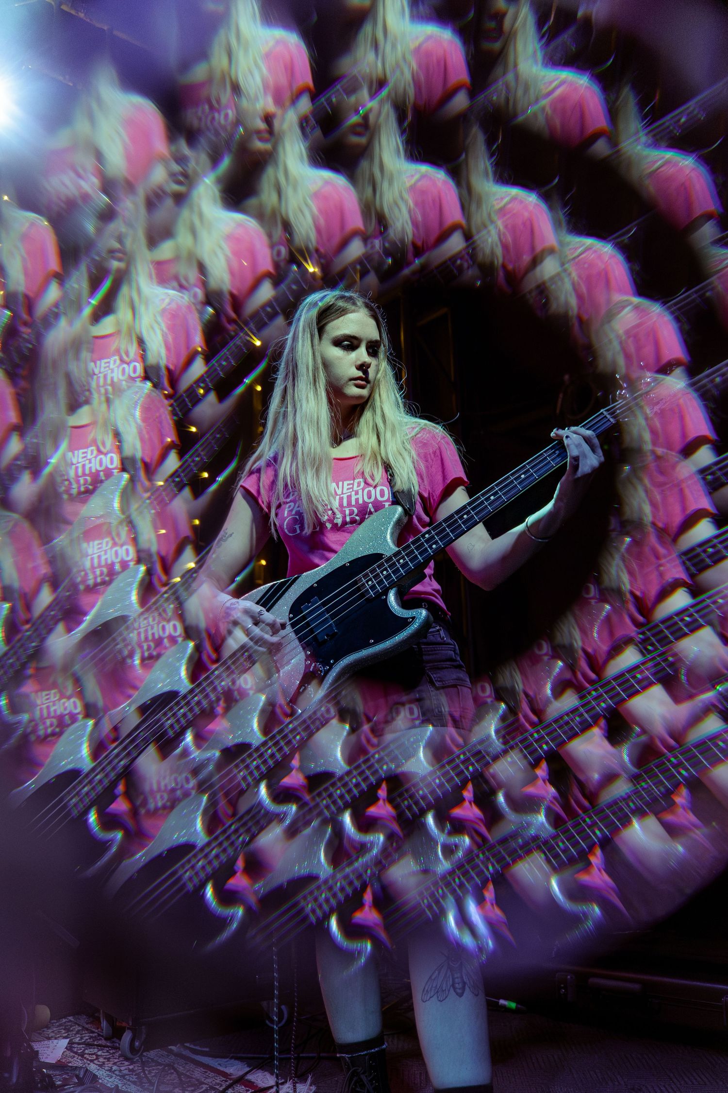 Multiple overlapping images show a performer in black clothing playing electric guitar during a concert performance.