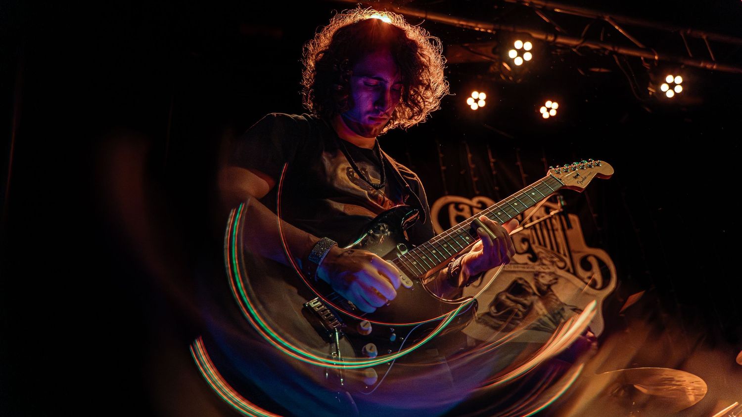 Soccer balls hover in dark space surrounded by glowing neon light trails and colorful reflective metallic surfaces.