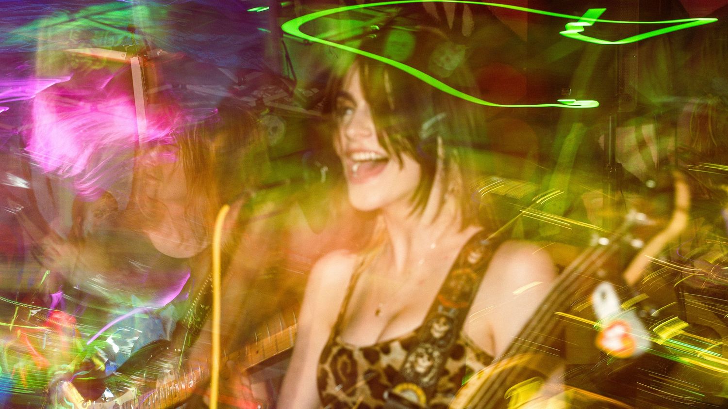 Abstract concert photography with colorful light trails creating psychedelic patterns in pink and green.